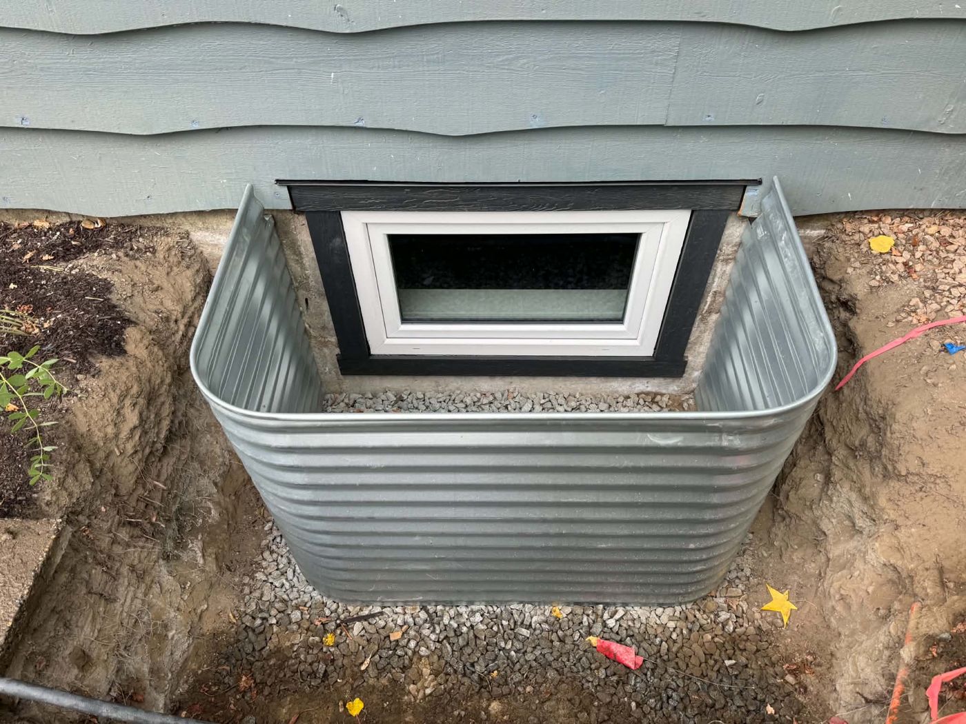 Basement window with trim and a new window well