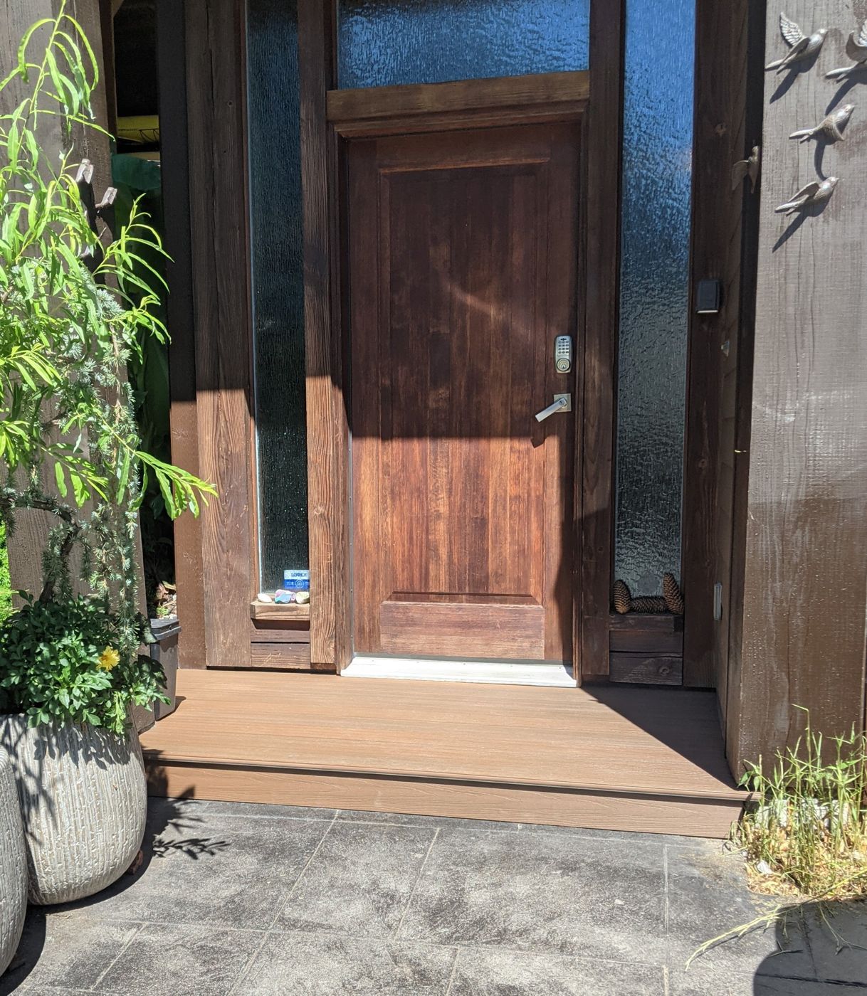Composite entry step and landing at a wood front door